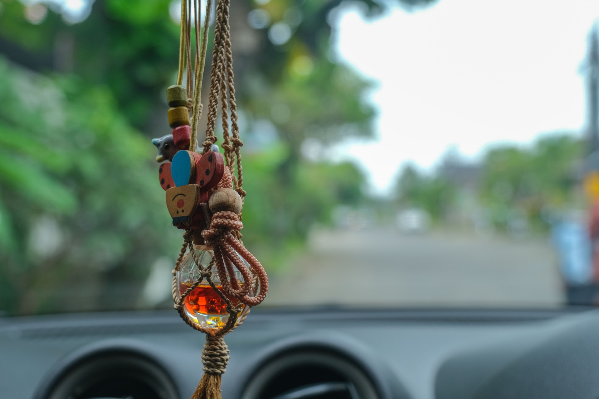 A bottle of air freshener and decorative ornaments hung from the interior mirror handle.